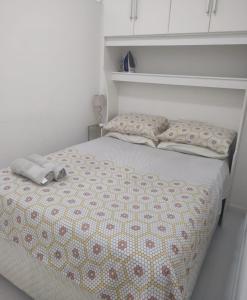 Una cama blanca con dos almohadas encima. en Copacabana Av princesa isabel y atlantica, en Río de Janeiro