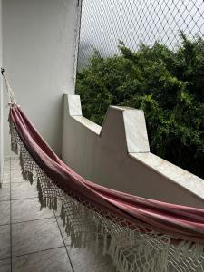 a hammock on the side of a balcony at Apto Espaçoso no Centro de Ubatuba - 3 quartos, 2 vaga garagem,2 banheiros,Cozinha Completa in Ubatuba