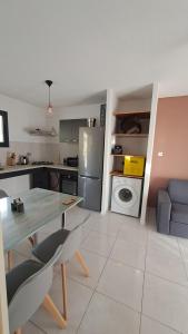 a kitchen with a table and chairs and a refrigerator at La Kay Cassi in Saint-Pierre