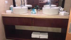 a bathroom with two sinks and two mirrors at Boutique Casa Azuli Santiago in Mérida