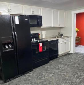 una cocina con electrodomésticos negros y armarios blancos en The Cottages on Carbon Avenue, en Price