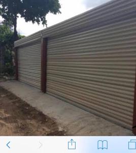 a large metal garage door on the side of a house at Cabina Grande en Brasilito con piscina a 2 min caminando de playa brasilito in Brasilito