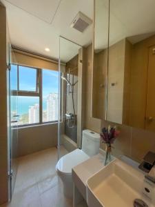 a bathroom with a toilet and a shower and a sink at The Song Vũng Tàu Luxury House in Vung Tau