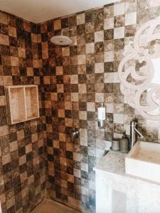 チャングーにあるHappy Days Villaのタイル張りの壁、洗面台付きのバスルーム