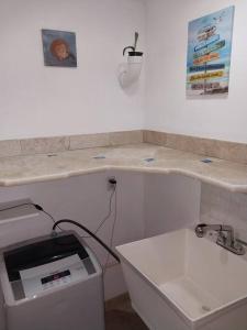 a white kitchen with a counter and a sink and a counter at Apartment near Grace Bay Beach in Providenciales