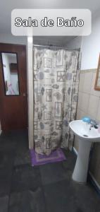 y baño con cortina de ducha y lavamanos. en Departamento a pasos de Cavancha, en Iquique