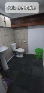 a bathroom with a toilet and a sink at Departamento a pasos de Cavancha in Iquique