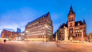 a large building with a clock tower in a city at Manchester Serviced Accomodation NorthernNightzzz - The Gardens in Manchester