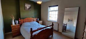 um quarto com uma cama, uma cómoda e uma janela em Victorian Semi Detached House behind the High Street em Newton in Makerfield