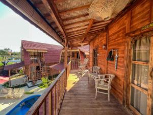 una terraza con sillas y mesas en una casa en Melasti Mountain Villas, Amed, Room 3 Agung Guesthouse, en Amed