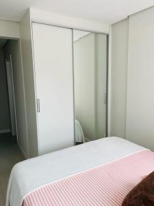 a bedroom with a bed with sliding glass doors at Apartamento na Praia de Palmas com garagem in Governador Celso Ramos