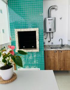a kitchen with a sink and a green tiled wall at Apartamento na Praia de Palmas com garagem in Governador Celso Ramos