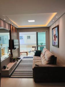 un salon avec un canapé et une télévision dans l'établissement Apartamento na Praia de Palmas com garagem, à Governador Celso Ramos 25 autres photos