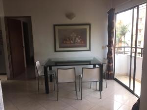 a dining room with a black table and chairs at Bueno y amplio apartamento en el barrio mas cool del Mundo , Laureles in Medellín