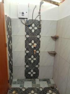 a bathroom with a shower with a tile floor at Panglao Vacation Home in Panglao Island