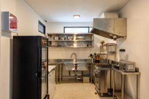 una cocina con electrodomésticos de acero inoxidable y fregadero en Paripadi Studio Canggu, en Canggu