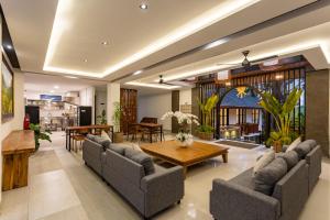a living room with couches and a wooden table at Paripadi Studio Canggu in Canggu