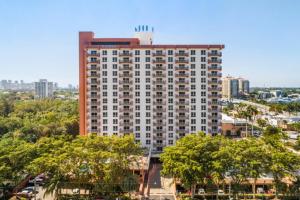 un grand bâtiment avec des arbres devant une ville dans l'établissement Fort Lauderdale Beach Resort by Vacatia, à Fort Lauderdale