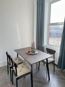 mesa de comedor con sillas y ventana en Longsands Apartment, Tynemouth Luxury Coastal Retreat, en Tynemouth