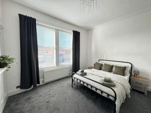1 dormitorio con cama y ventana grande en Longsands Apartment, Tynemouth Luxury Coastal Retreat, en Tynemouth