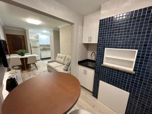 a kitchen and dining room with a table in a room at Apto super luxo beira mar Capão da Canoa in Capão da Canoa