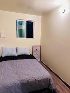 1 dormitorio con cama y ventana en Zen Home, en Santa Ana