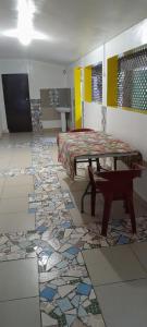 a room with a table and a floor with tiles at Penu Maurua lodge in Te-Fare-Arii