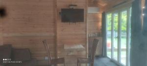 a living room with a television on a wooden wall at Homestead B&B Cambridge in Cambridge