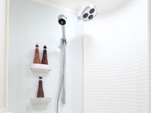 a shower with a shower head and bottles on the wall at Tokyu Stay Kamata - Tokyo Haneda in Tokyo