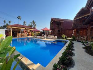 a large blue swimming pool next to some buildings at Melasti Mountain Villas, Amed, Room 3 Agung Guesthouse in Amed