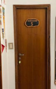 a wooden door with a sign on it at Hostel Sauce in Mar del Plata