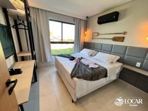 sypialnia z łóżkiem i oknem w obiekcie Eco Resort Praia dos Carneiros - Flats & Bangalô - LocarHouse w mieście Praia dos Carneiros