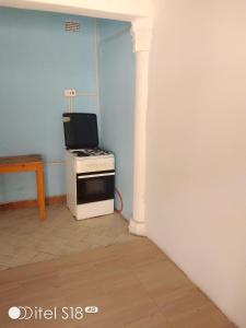 a small kitchen with a stove and a table at AKs in Lusaka