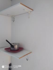 a kitchen shelf with a pot on a stove at AKs in Lusaka