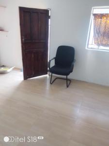 a black chair sitting in a room with a door at AKs in Lusaka