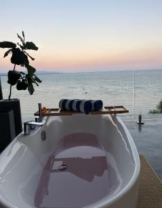 a white bath tub with a view of the ocean at Epic Suites Bohol ADULTS ONLY in Dauis