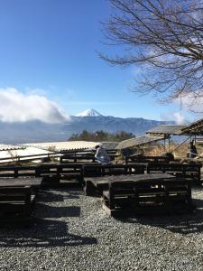 um grupo de mesas de piquenique com uma montanha ao fundo em Fujimien em Fujikawaguchiko