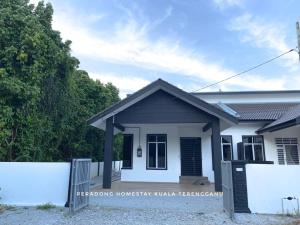 una casa bianca con una recinzione di fronte di Peradong Homestay Kuala Terengganu - Near Jetty Batu Hampar a Kuala Terengganu