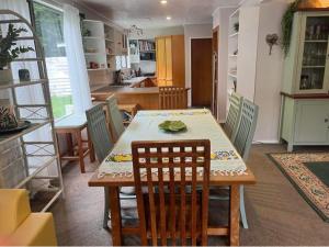 a kitchen and dining room with a table and chairs at Waiara Riverside Home in Taupo