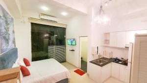 a white room with a bed and a sink at Lotus Colombo Guesthouse in Colombo