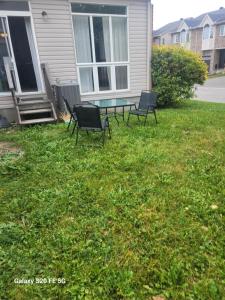 a patio with two chairs and a table in the yard at Three-room townhouse in Ottawa