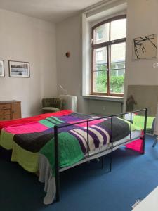 a bedroom with a bed with a colorful blanket at Art Loft in Cologne