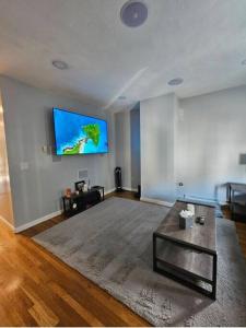 a living room with a flat screen tv on a wall at Newly renovated -2 Bedroom Condo in Boston