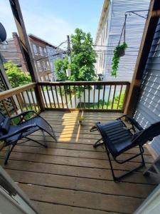 a deck with two chairs and a bench on it at Newly renovated -2 Bedroom Condo in Boston