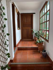 um corredor com uma porta de madeira e algumas plantas em Oasis san José de la villa em Villa de Leyva