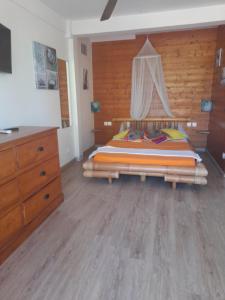 um quarto com uma cama e uma cómoda em Lacréola em Saint-Joseph