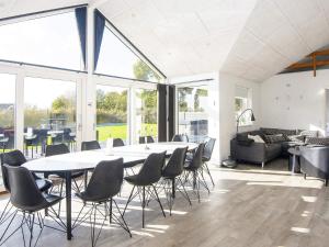 a large table and chairs in a room with windows at 5 star holiday home in Haderslev-By Traum in Haderslev