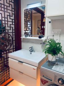 a bathroom with a sink and a mirror at Gorgeous apartment with private backyard in Wuhan