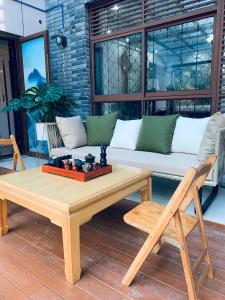 a living room with a couch and a table and chairs at Gorgeous apartment with private backyard in Wuhan
