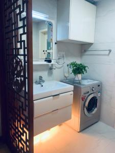a bathroom with a washing machine and a sink at Gorgeous apartment with private backyard in Wuhan